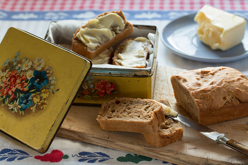Stukken zelfgemaakte kruidkoek met boter op een houten plank